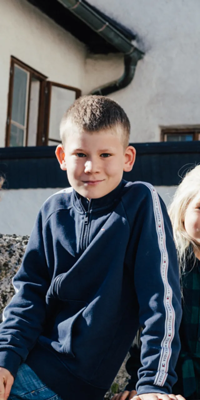 Gruppe von fünf Kindern vor einem alten Steingebäude im Freien