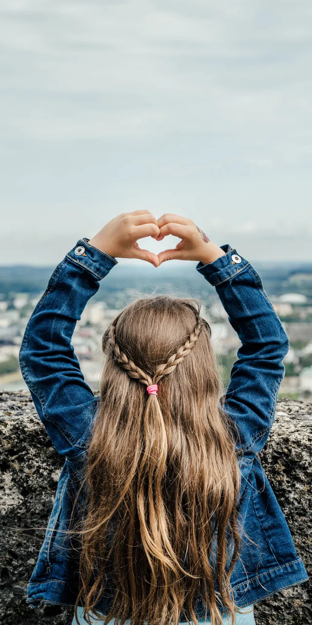 Kind macht mit Händen eine Herzform