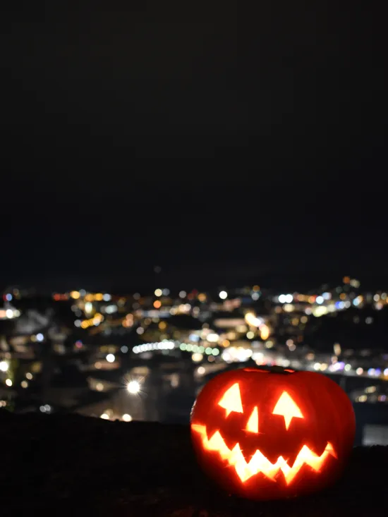 Lanterna di Halloween illuminata con luci della città sullo sfondo notturno