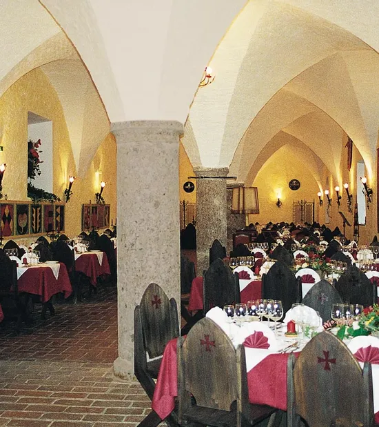 Medieval-style banquet hall with arched ceilings and tables set for dining