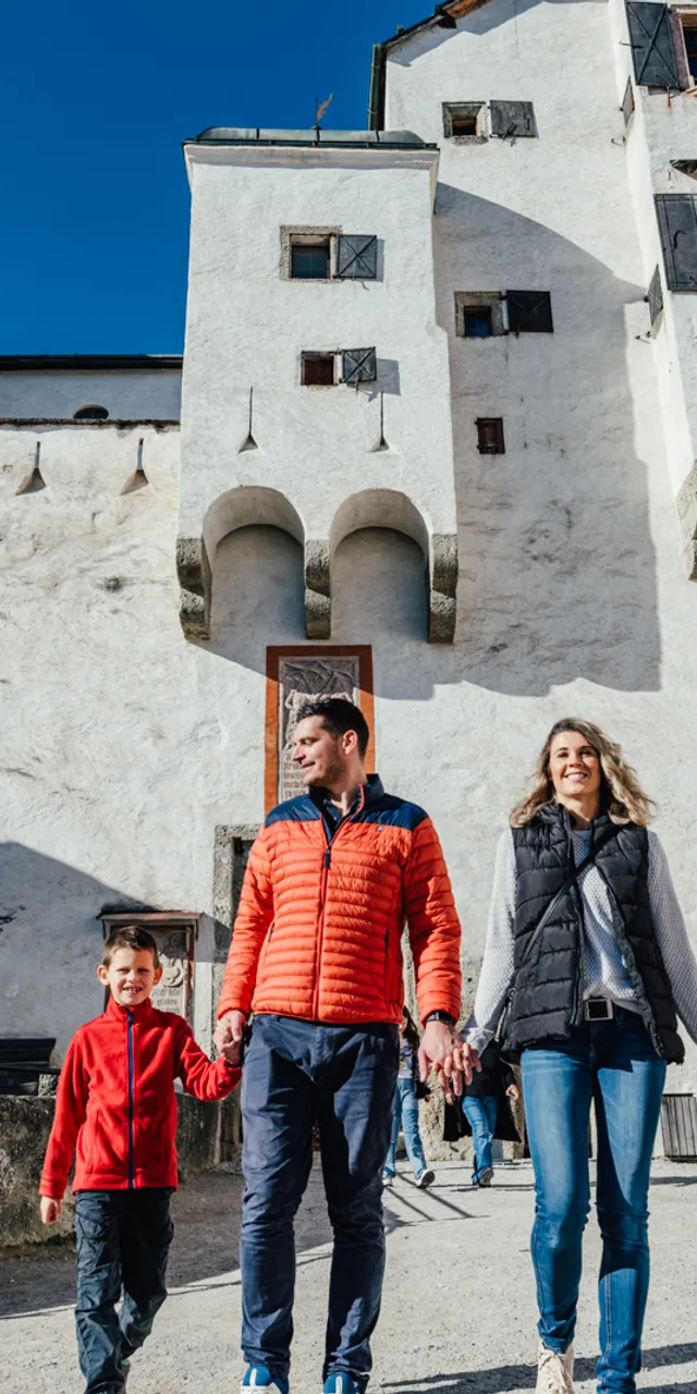 Famiglia che cammina davanti a un castello storico bianco in una giornata di sole