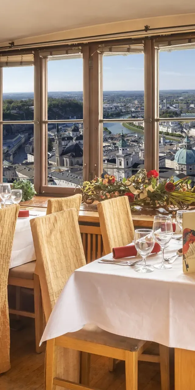 elegante-restauranttische-an-panoramafenster-mit-blick-auf-salzburgs-stadtlandschaft.jpg