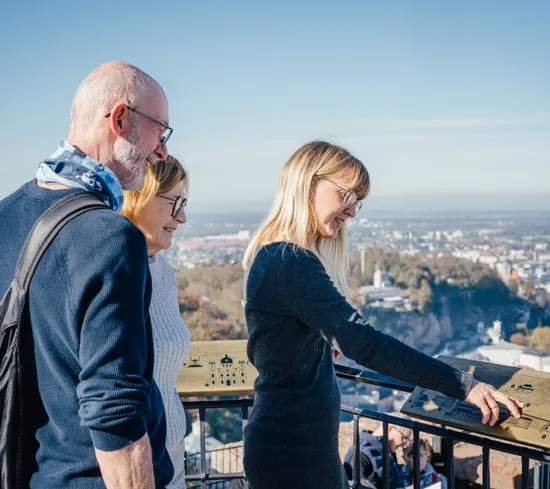 Turisti leggono un pannello informativo con vista panoramica su Salisburgo
