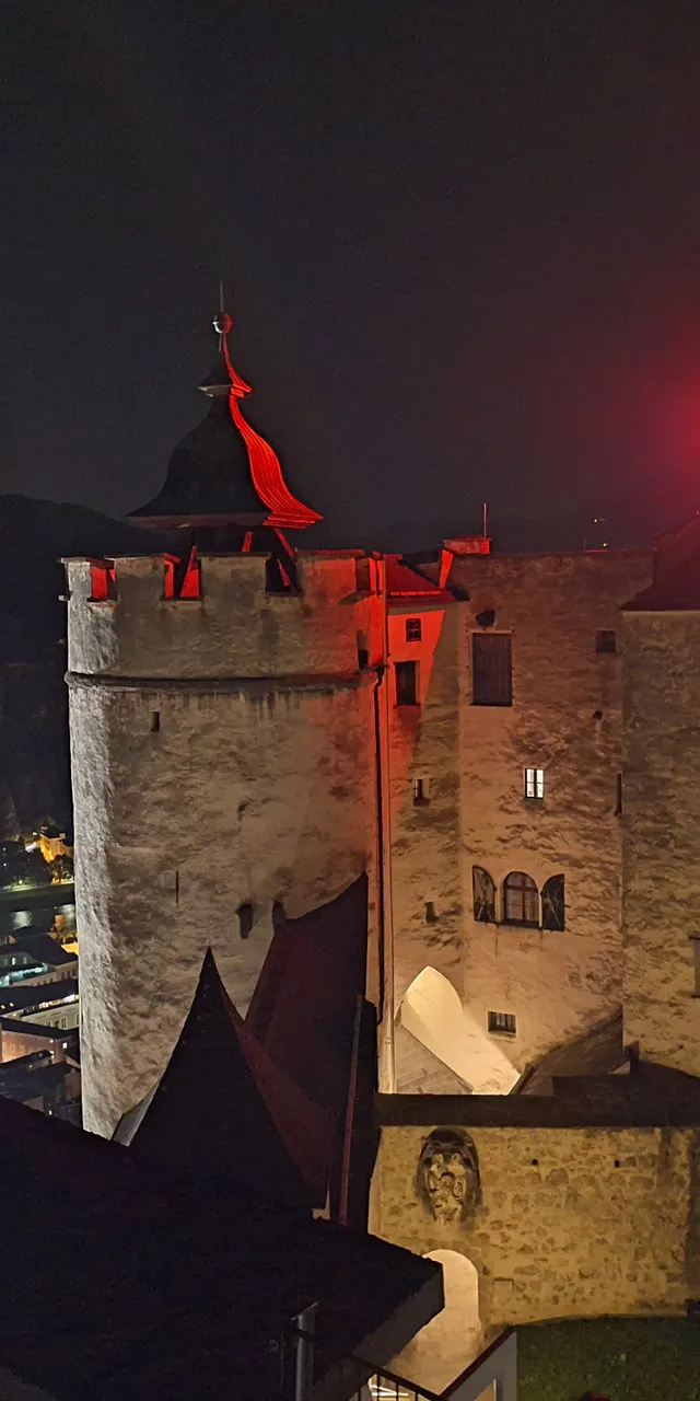 Mittelalterlicher Burghof bei Nacht in Salzburg von roten Lichtern beleuchtet