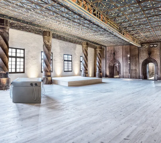 Sala storica con colonne tortili decorate, pavimento in legno e soffitto ornato