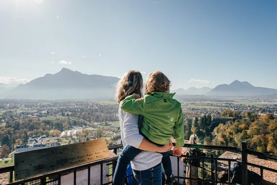 Mother and child enjoying panoramic mountain view from Salzburg viewpoint