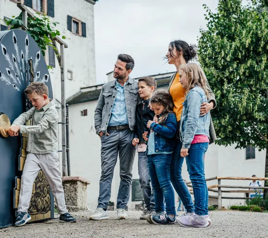Famiglia con bambini esplora una mostra interattiva in un museo all’aperto