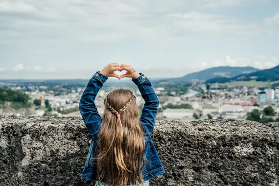 Kind macht mit Händen eine Herzform