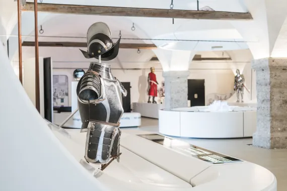 Medieval knight armor display in a museum with arched stone architecture