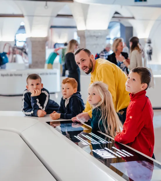 Man and children exploring interactive exhibit at science or history museum