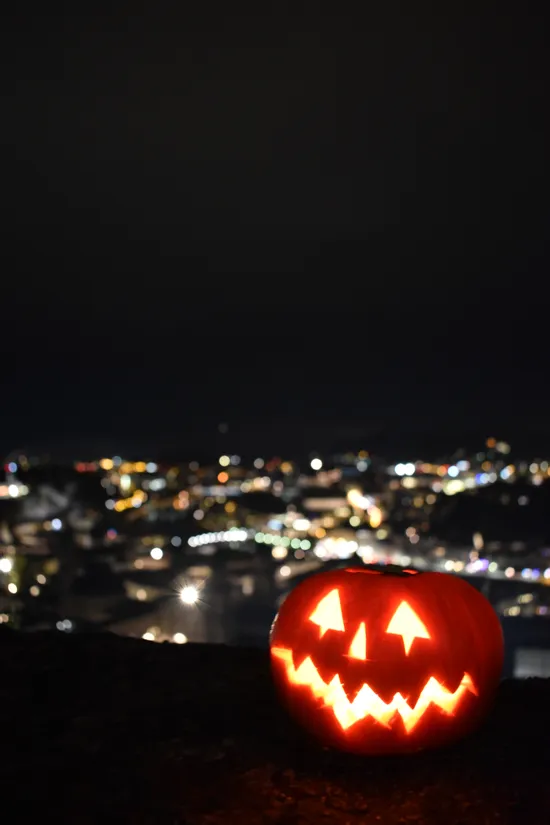 Lanterna di Halloween illuminata con luci della città sullo sfondo notturno