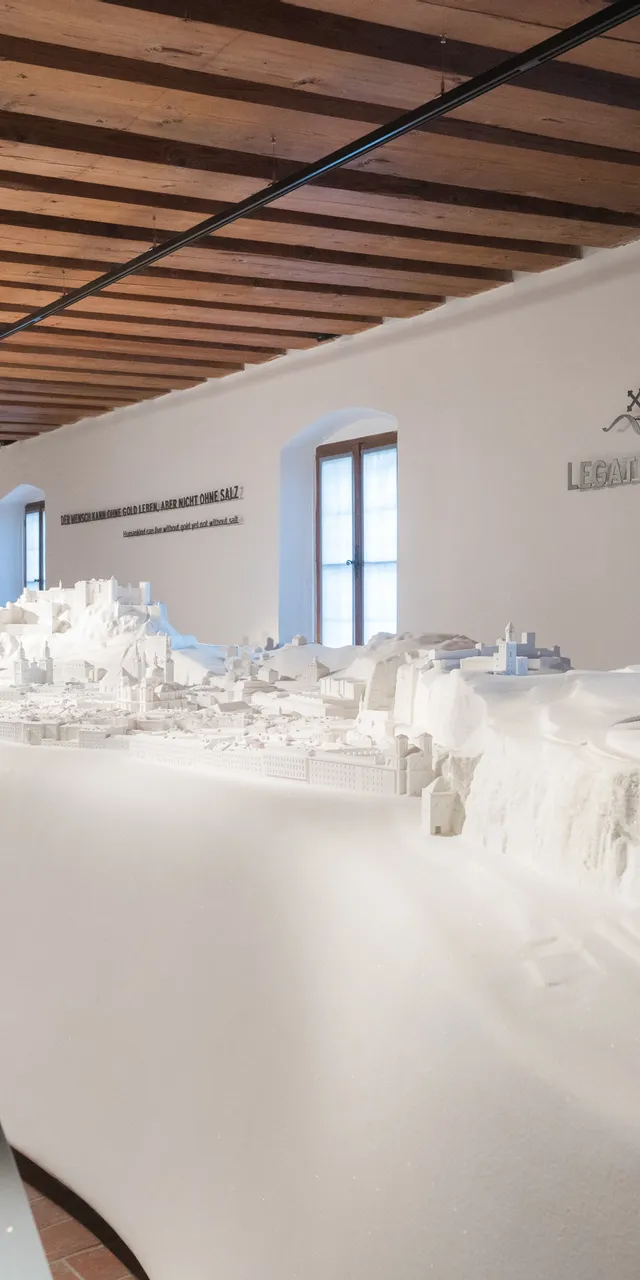 Detailliertes weißes 3D-Stadtmodell in einem Museum mit Holzdecke und gebogenen Ausstellungsflächen