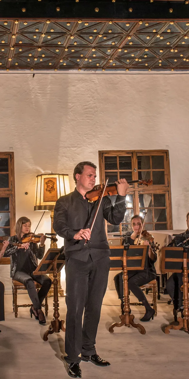 Kammerorchester spielt in einem warm beleuchteten historischen Raum