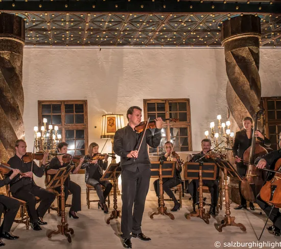 Orchestra da camera suona in una sala storica illuminata caldamente